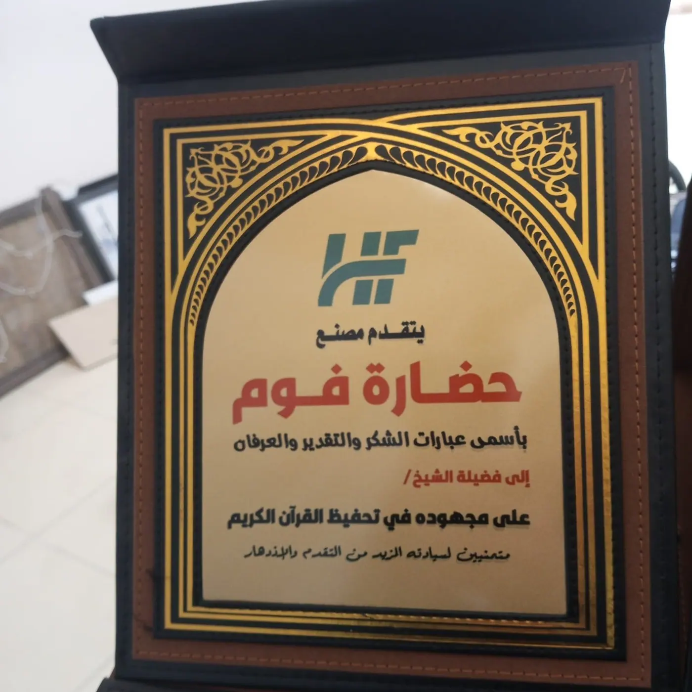 درع بإطار خشبي وشريحة ذهبية مطبوعة بنص تكريم