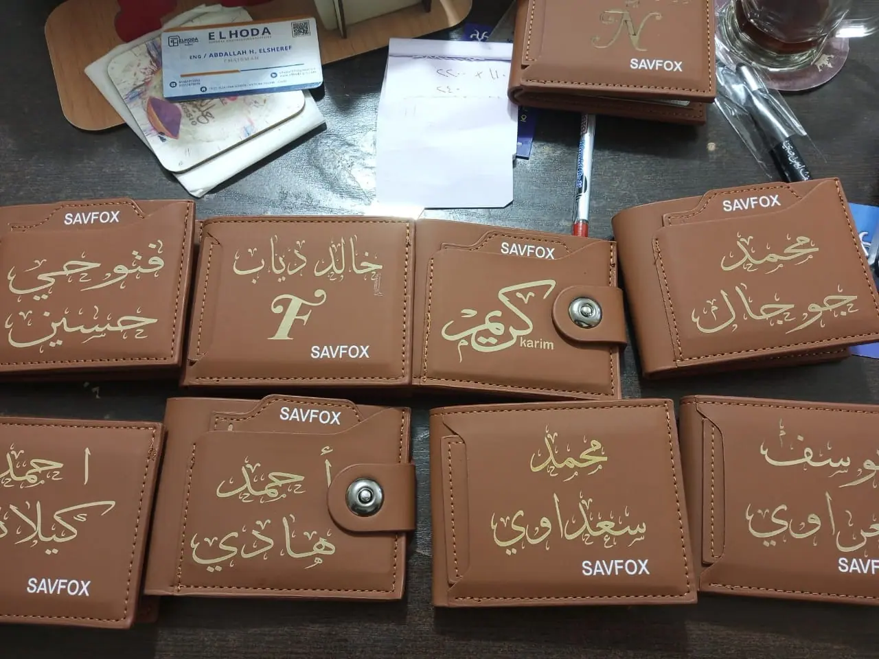 محافظ جلد محفور عليها أسماء بالعربي