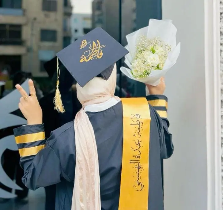 خريجتان تحملان كابات تخرج مطبوعة يوم الحفل
