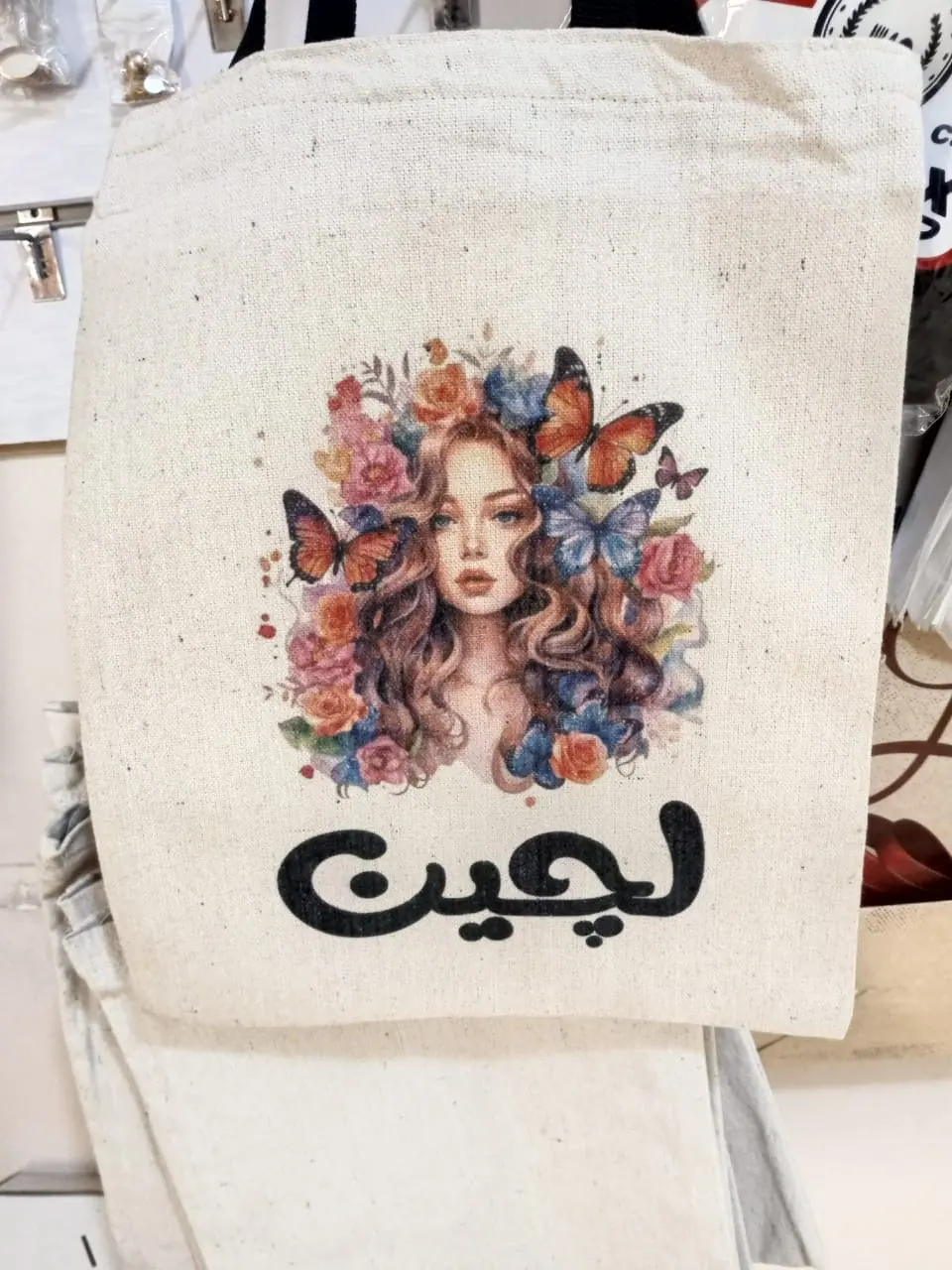 شنطة قماش مطبوعة بتصميم فراشات واسم بالعربي
