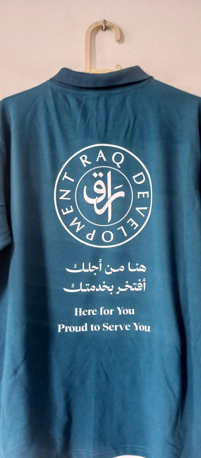 بولو بأكمام طويلة مطبوع بشعار الشركة وشعارها النصي